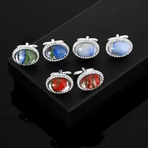 Gros plan de trois paires de boutons de manchette ovales avec halo de cristal et marbre