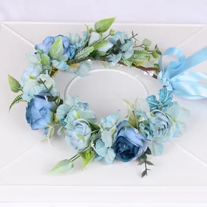 Détail d'une couronne de fleurs bleues réalistes avec pétales en soie et ruban satin