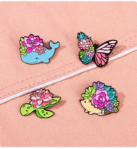 Detailed view of colorful enamel pins featuring cute animals and succulent plant designs