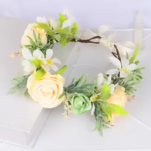 Détail d'une couronne de fleurs avec roses jaunes, feuilles vertes et ruban de satin