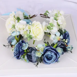 Vue détaillée de couronnes de fleurs faites main avec roses blanches, bleues et rubans