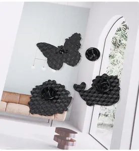 Detailed back view of metal badges with butterfly, flower and whale shaped textures