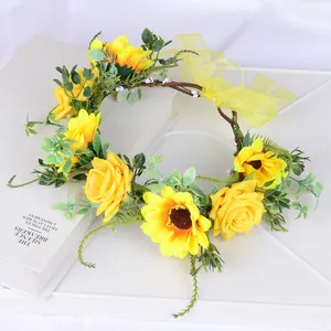 Détail d'une couronne de tournesols et roses avec ruban jaune sur fond de livre