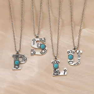 Detail of vintage bohemian initial necklaces with turquoise and western style engravings