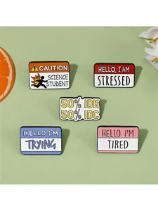 Close-up of alloy enamel pins with funny phrases like Hello I am Tired on green background