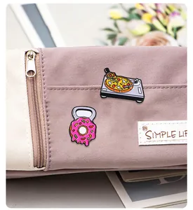 Détails des pins émaillés tourne-disque pizza et donut kettlebell sur un sac en toile