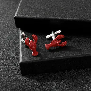 Detail view of red lobster enamel cufflinks set on black leather jewelry box