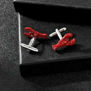 Detailed view of red lobster cufflinks with silver finish on a black textured box