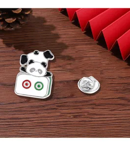 Detailed view of panda mahjong enamel pin on dark wood with red fan and pine cones