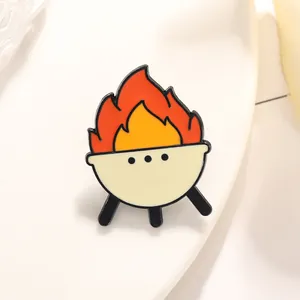 Creative BBQ grill enamel pin with vibrant orange and yellow flames on a white background