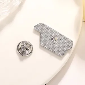 Back view of silver irregular metal badge with anti-slip texture and butterfly clasp