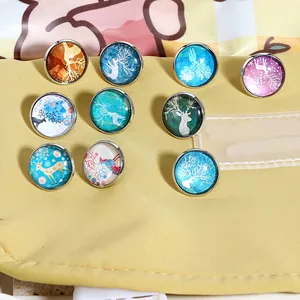 Vue détaillée de dix broches artistiques en verre de renne sur un sac en tissu jaune