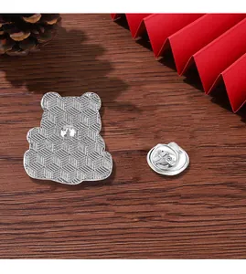 Detail view of the silver metal panda badge back with textured pattern and butterfly clutch