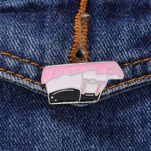 Macro detail of an irregular enamel lapel pin with anime aesthetic on denim fabric