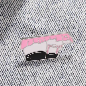Detailed view of pink enamel pin with heart garter detail on denim jacket fabric