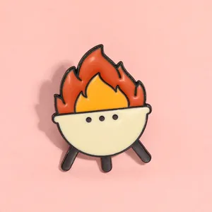 Detail of creative campfire grill enamel pin with vibrant orange flames on pink background