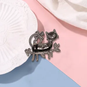 Back view of cute cat enamel brooch with secure metal pin on pink and blue background