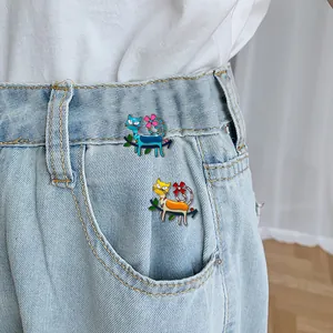 Cute enamel cat brooches set with flower details on blue denim jeans pocket