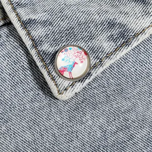 Gros plan d'une broche en cristal d'élan colorée épinglée sur un tissu en denim bleu clair