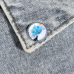 Vue macro d'une broche cerf ronde avec bois fleuris bleus sur tissu denim clair