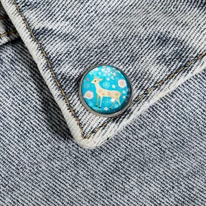 Détail macro d'une broche en verre à motif cerf épinglée sur un col en denim