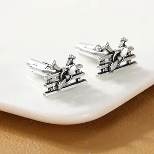 Macro detail of vintage silver biplane cufflinks with propeller and wing structures