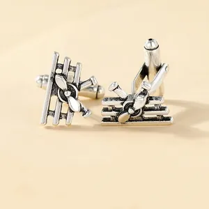 Macro view of vintage silver biplane cufflinks with detailed propellers and wings