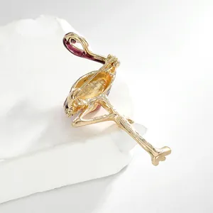 Vue détaillée de l'arrière d'une broche flamant rose dorée avec épingle et texture émail