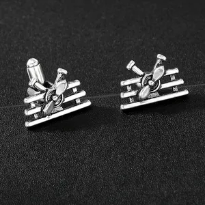 Detail of vintage silver airplane cufflinks with propeller design on black background