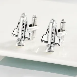 Macro shot of silver vintage airplane cufflinks with intricate wing and tail details