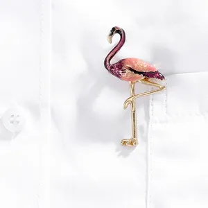 Broche flamant rose émaillée avec dégradé sur la poche d'une chemise blanche