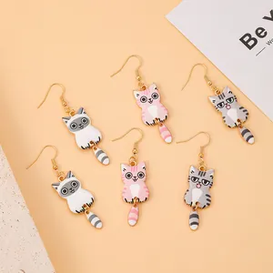 Detail of three pairs of enamel cat earrings in pink, black and grey with gold hooks