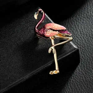 Vue détaillée d'une broche flamant rose élégante en émail sur fond de cuir noir texturé