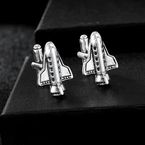 Macro shot of vintage silver aircraft cufflinks showing detailed wings and T-bar on black box