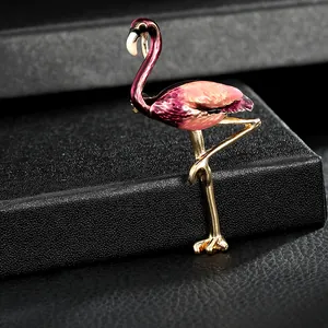 Détail d'une broche flamant rose en émail sur un coffret à bijoux noir texturé