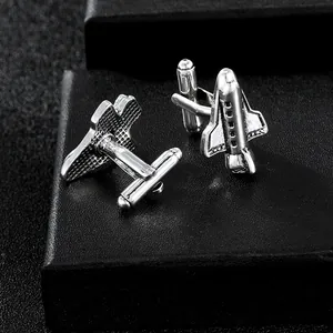 Macro shot of silver airplane cufflinks with detailed wings and polished steel finish