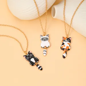 Detailed macro view of three colorful cartoon cat enamel pendants on gold chains