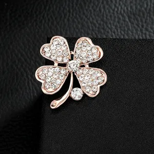 Eleganter vierblättriger Kleeblatt-Anstecker in Roségold mit Strass auf schwarzem Leder