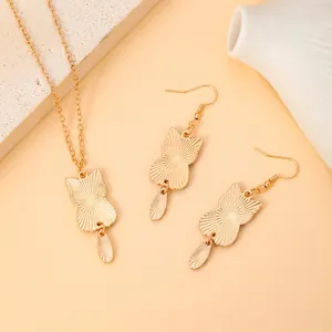 Close-up of golden cat jewelry set featuring sunburst texture on necklace and earrings