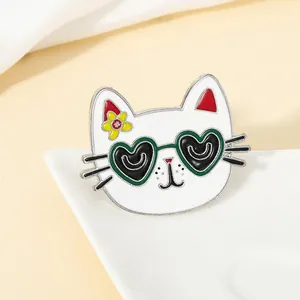 Detail of white cartoon cat enamel pin with green sunglasses and yellow flower detail