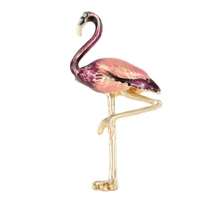 Broche flamant rose et violette avec placage or et œil en cristal sur fond blanc