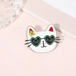 Detail of cartoon cat enamel pin with heart-shaped sunglasses and yellow flower accent