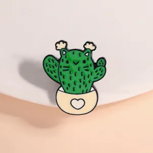 Close-up of a cute cactus cat enamel pin with a heart detail on the pot base