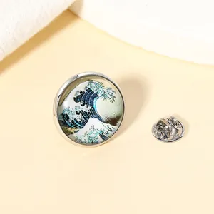 Broche en métal avec la Grande Vague de Kanagawa, cabochon en verre et fermoir papillon