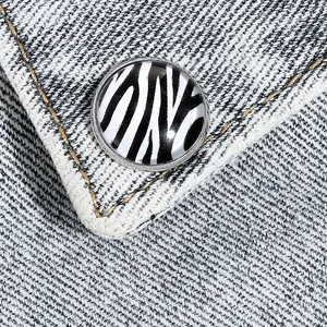 Bouton rond en émail à motif zèbre sur tissu denim avec rayures noires et blanches