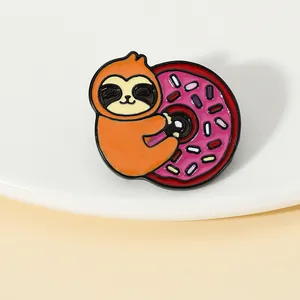 Macro detail of a creative enamel sloth hugging a pink donut brooch pin accessory