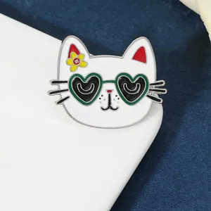 Macro shot of cute white cat enamel pin with heart-shaped sunglasses and a red flower
