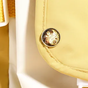 Macro di una spilla floreale yin yang vintage su dettaglio in tessuto di tela gialla