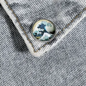 Gros plan d'un badge Vague de Kanagawa épinglé sur un col de veste en denim bleu