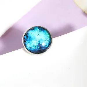 Detailed macro view of silver galaxy brooch with deep blue and green nebula glass gem